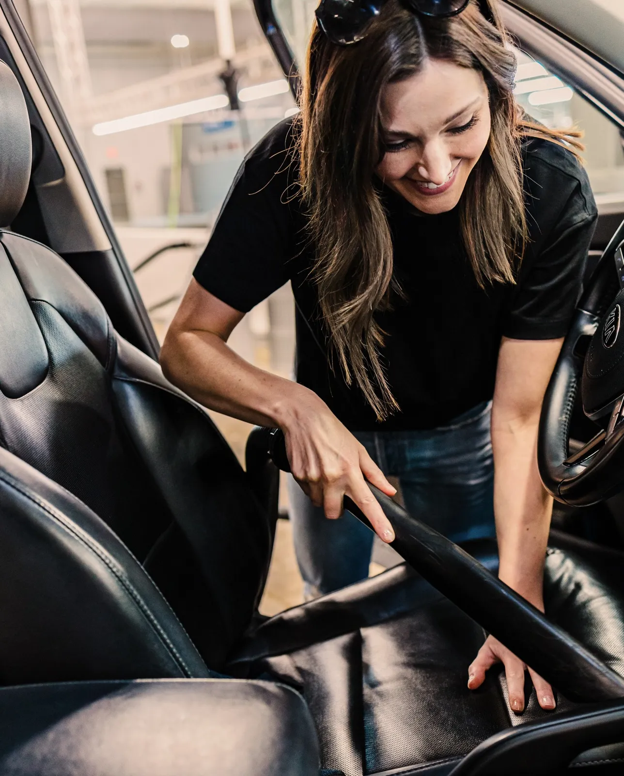 Woman vacuuming a car seat