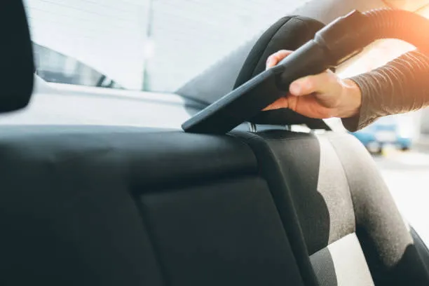 Vacuum nozzle cleaning a vehicle seat